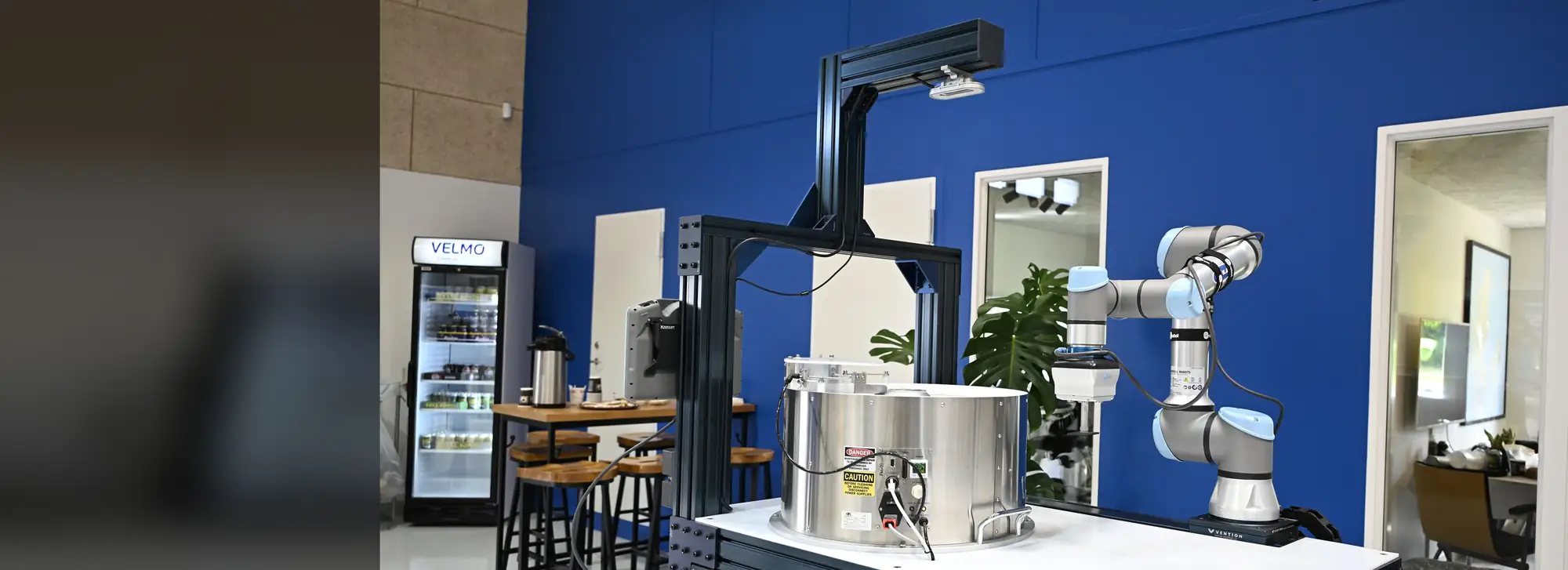 Cobot der betjener en maskine i en installation bygget af Velmo